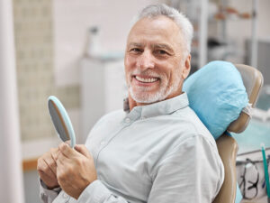 homem sorrindo com seus implantes dentários